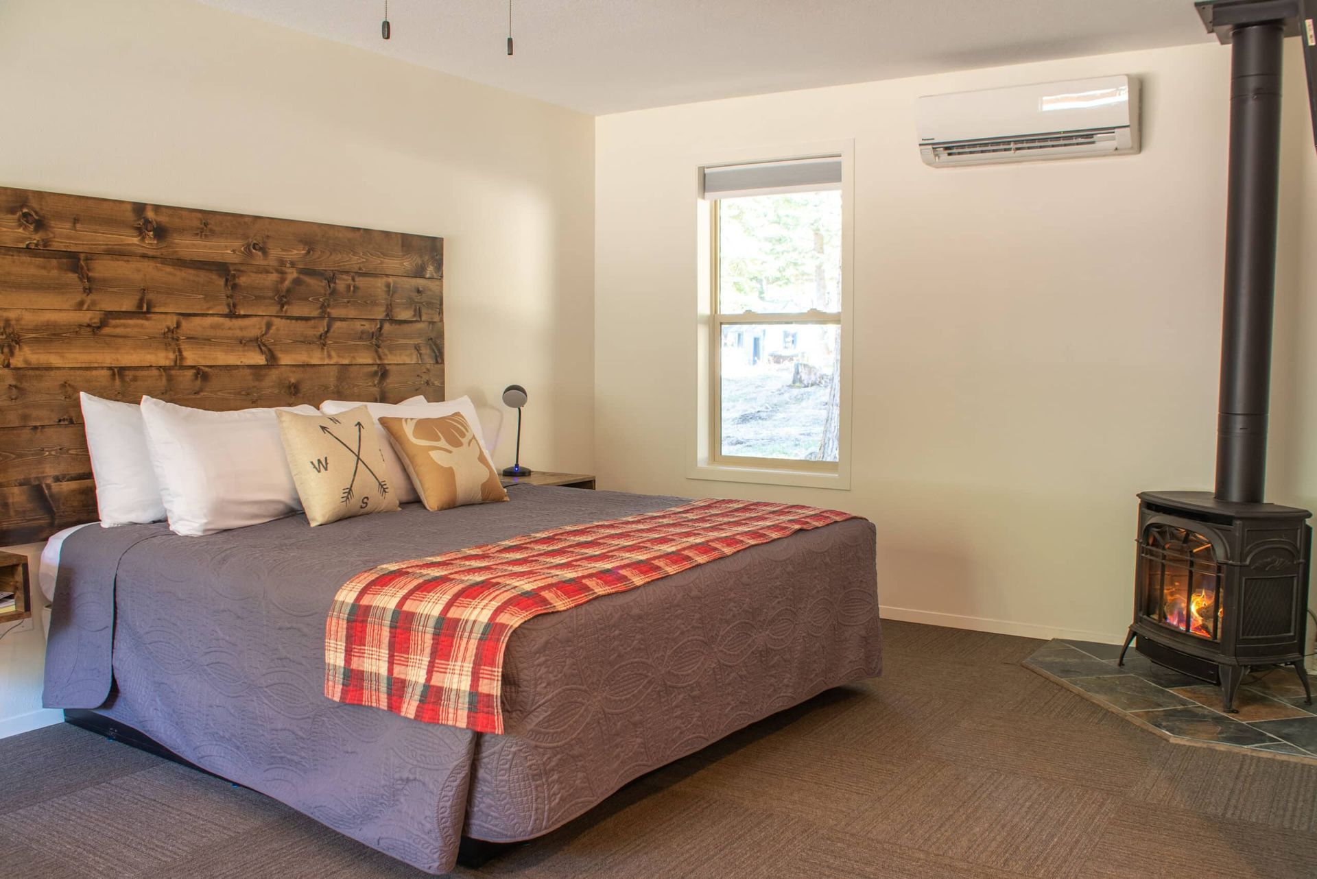 A bedroom with a king size bed and a wood stove.