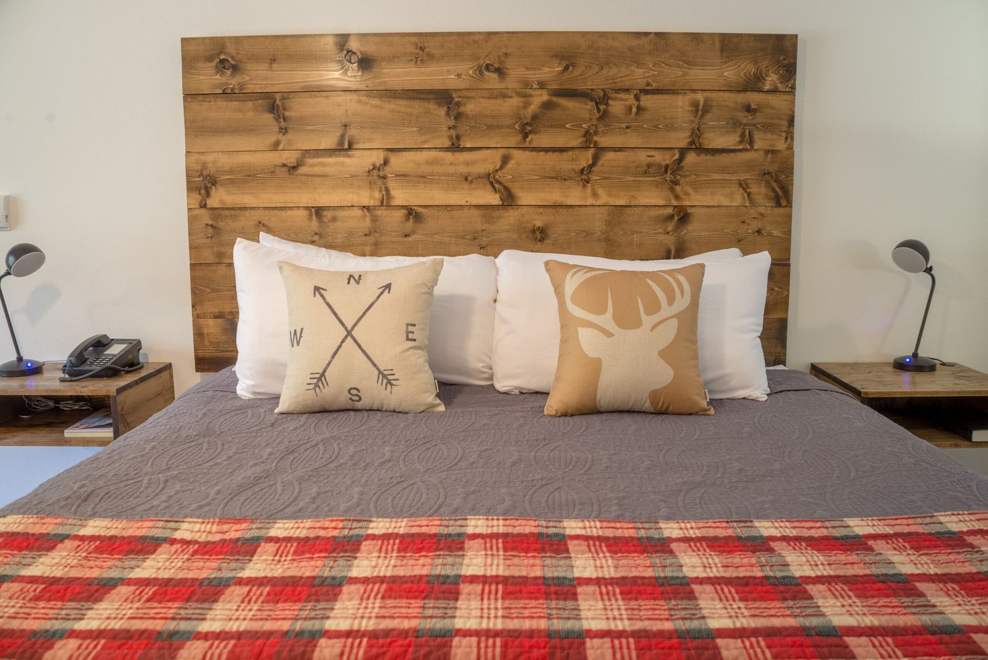 A bed with a wooden headboard and pillows on it.