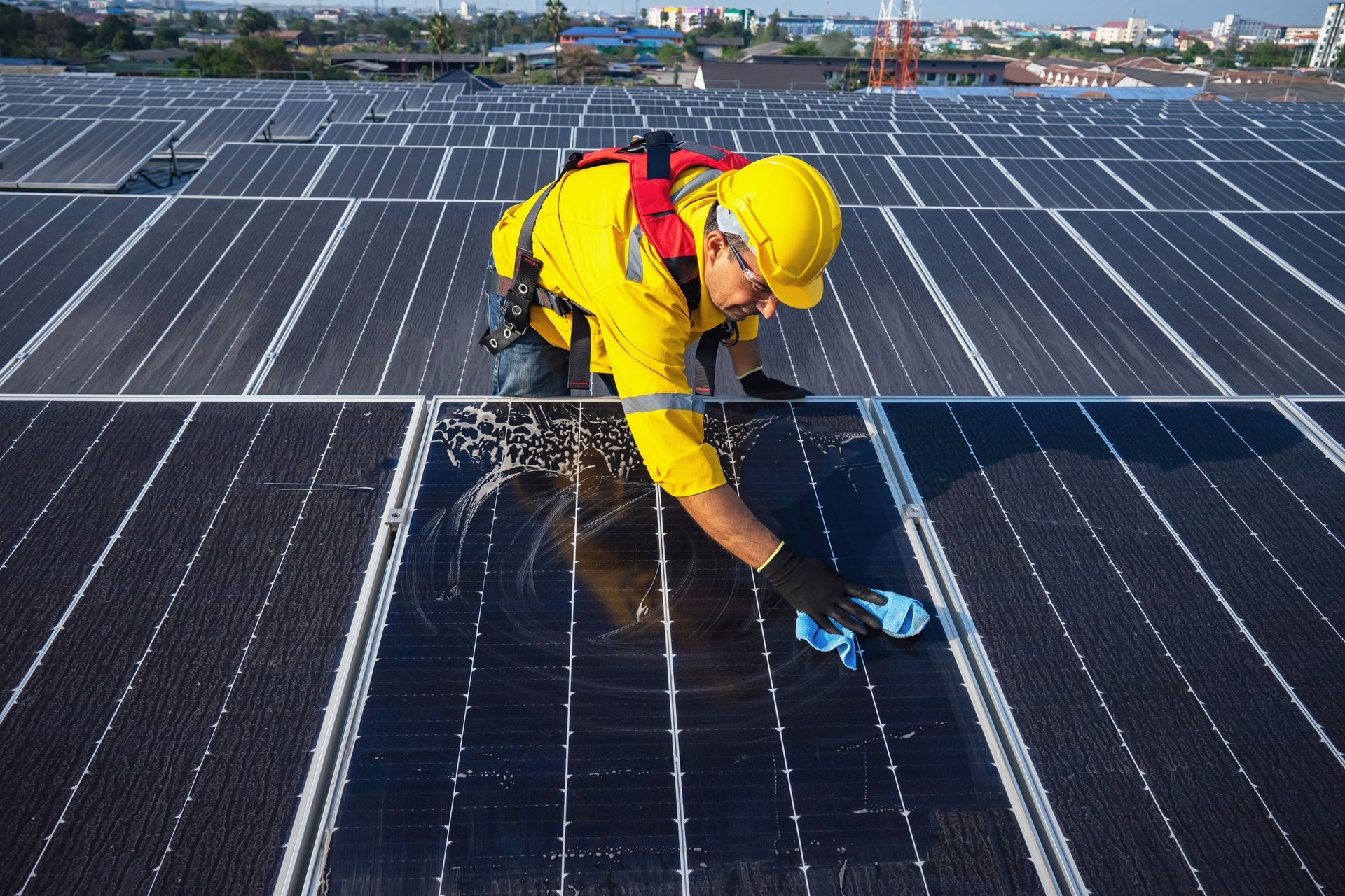 Un uomo sta pulendo un pannello solare con un panno.