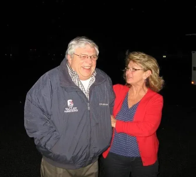 A man wearing a jacket that says columbia is standing next to a woman in a red sweater A man wearing a jacket that says columbia is standing next to a woman in a red sweater