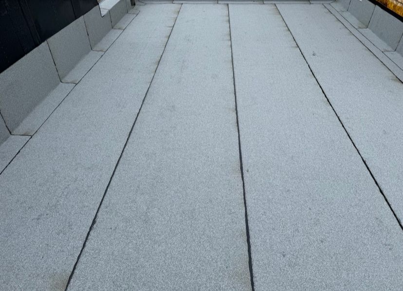 Gray concrete walkway or rooftop with parallel seams receding into the distance