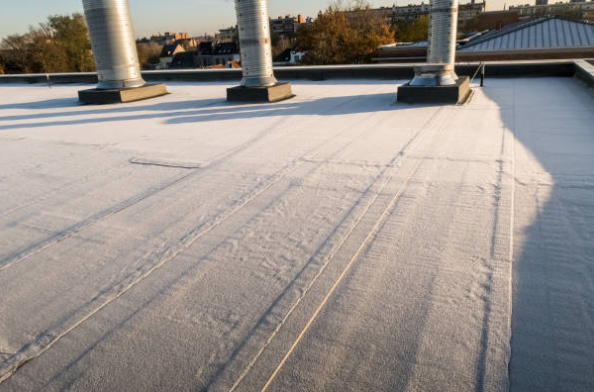 Snow-covered rooftop with vents and long shadows at sunset