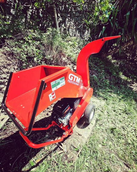 Un cippatore di alberi gtm rosso è seduto nell'erba