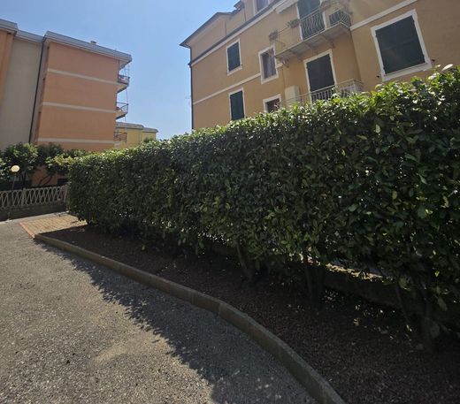 Un edificio con un balcone è dietro una siepe