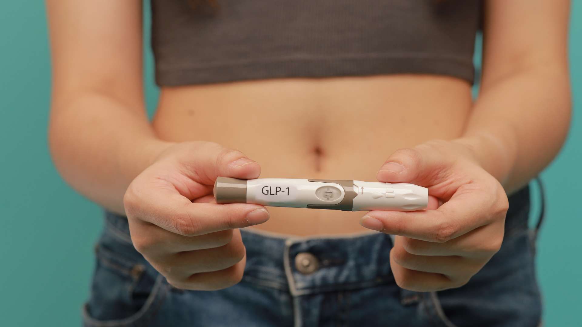 Hands holding a GIN pregnancy test with one line visible.