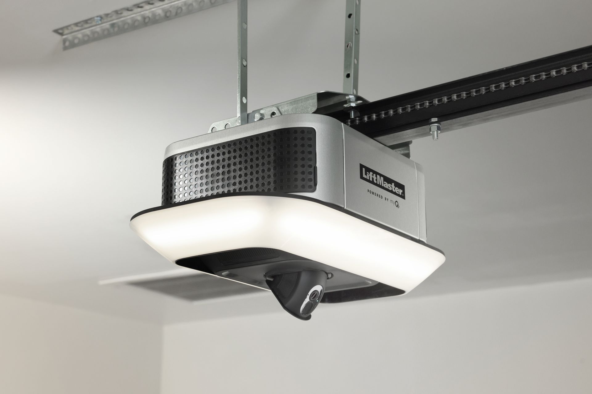 Ceiling-mounted garage door opener with built-in light, suspended from a metal track