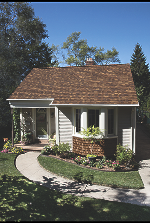A small house with a brown roof and a walkway leading to it