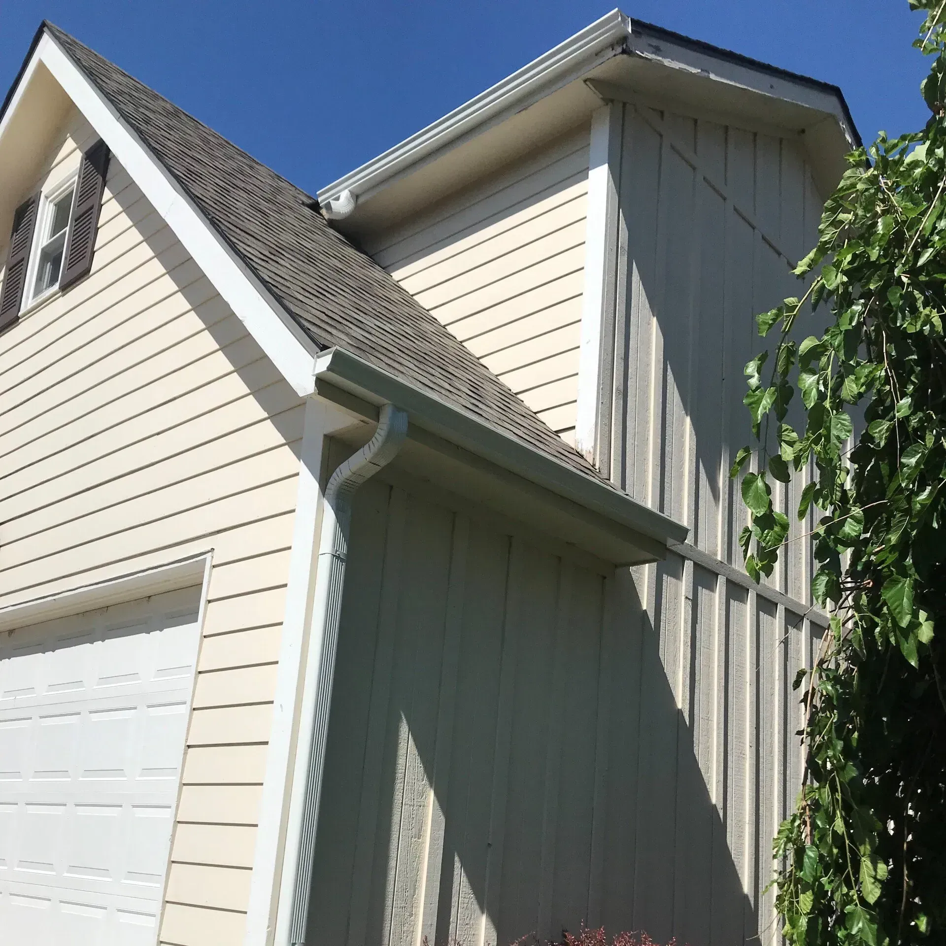 A white house with a gray roof and a white garage door