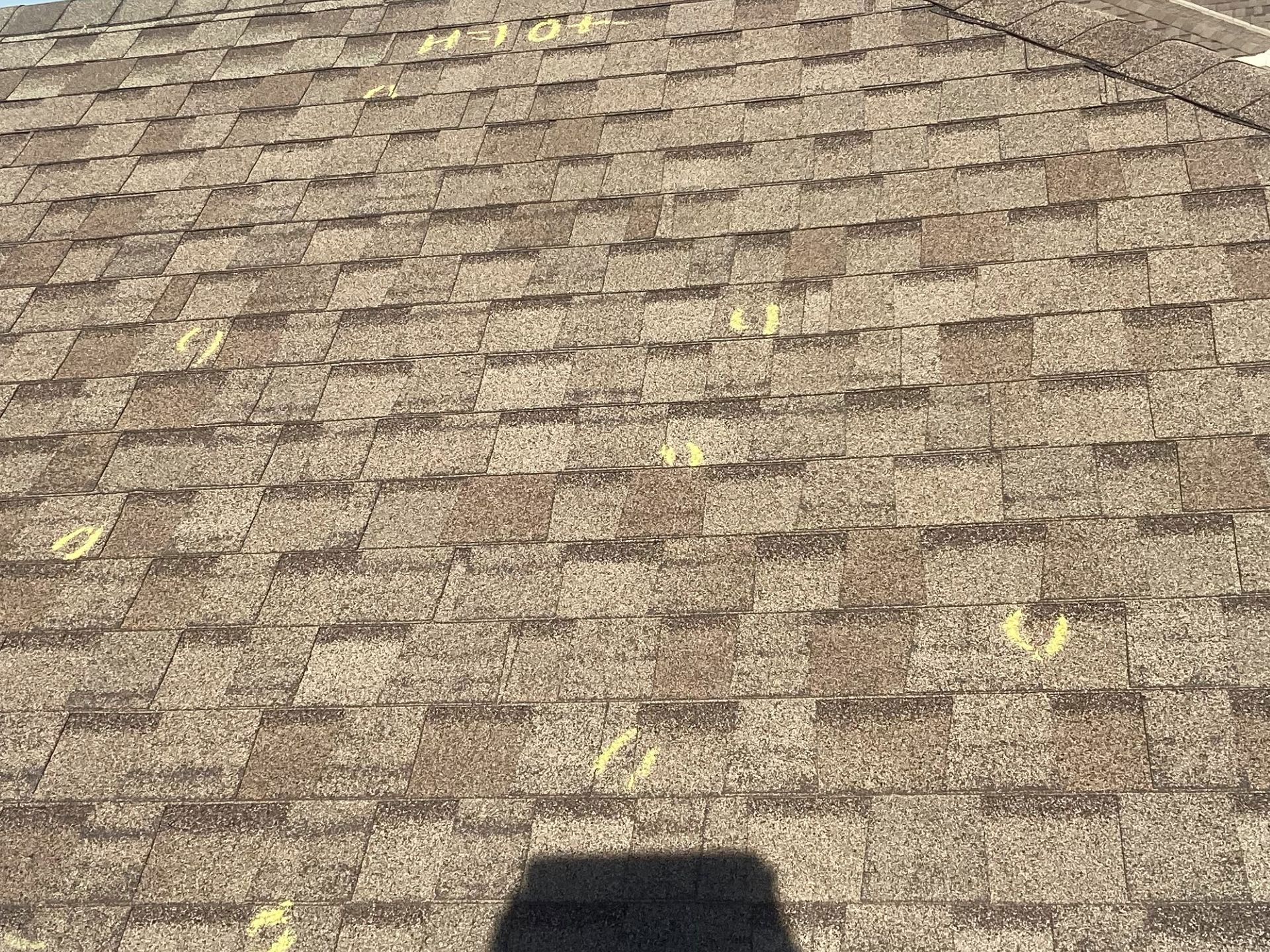 A close up of a roof with a shadow of a person on it.