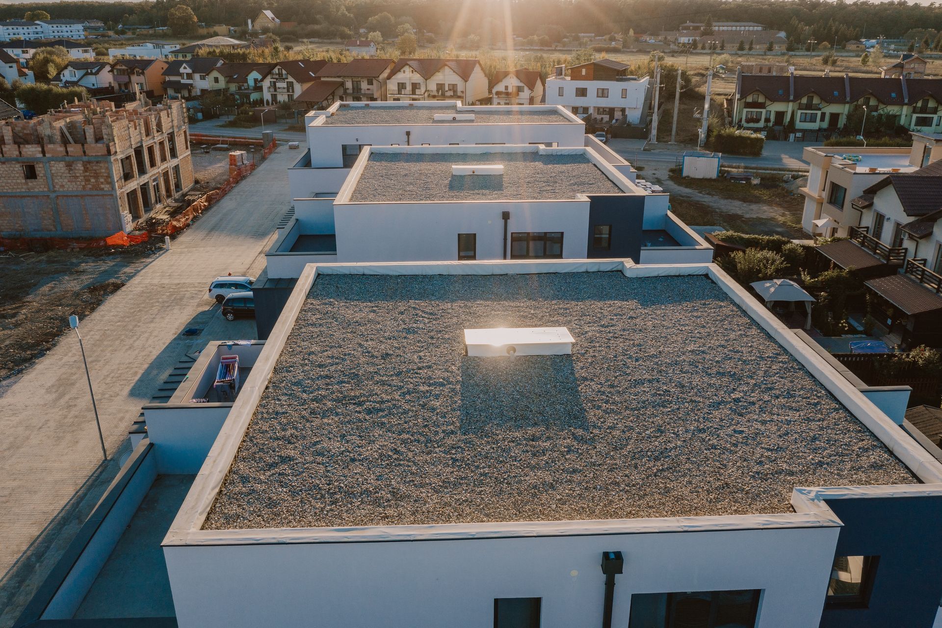 Aerial view of flat-roofed white buildings in a coastal town at sunset