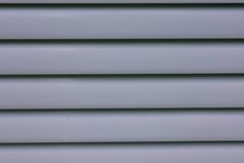 Light-blue horizontal slats, likely part of a window blind or wall paneling, with subtle shadows.