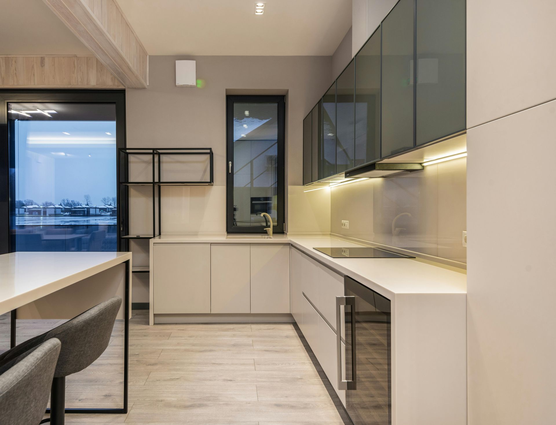 Modern kitchen with beige cabinets, light countertops, and dark trim.
