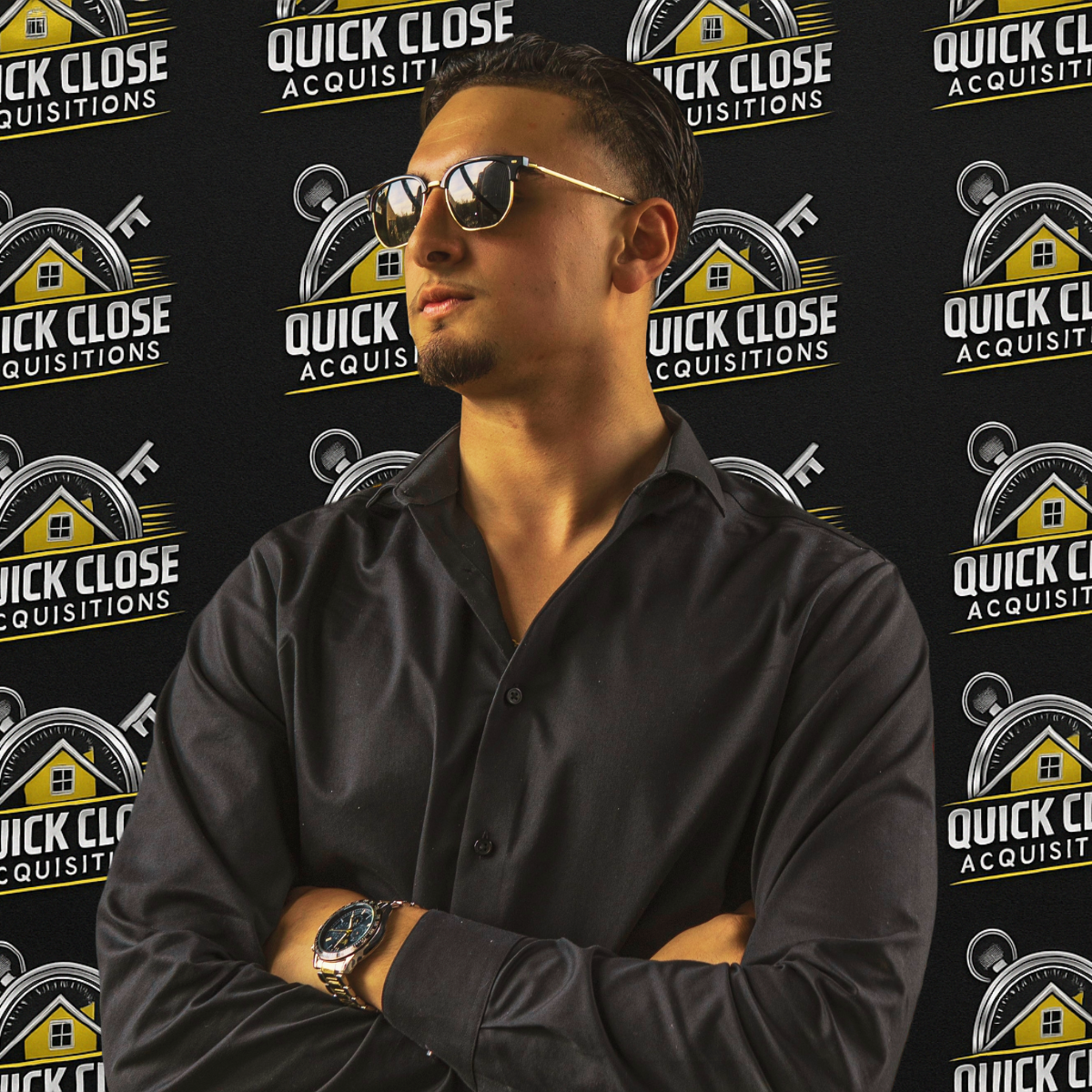 A man wearing sunglasses stands in front of a wall that says quick close