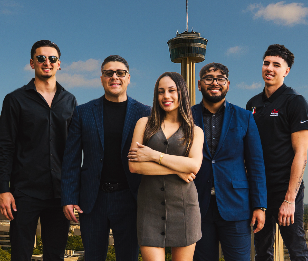A group of people are posing for a picture in front of a tower.
