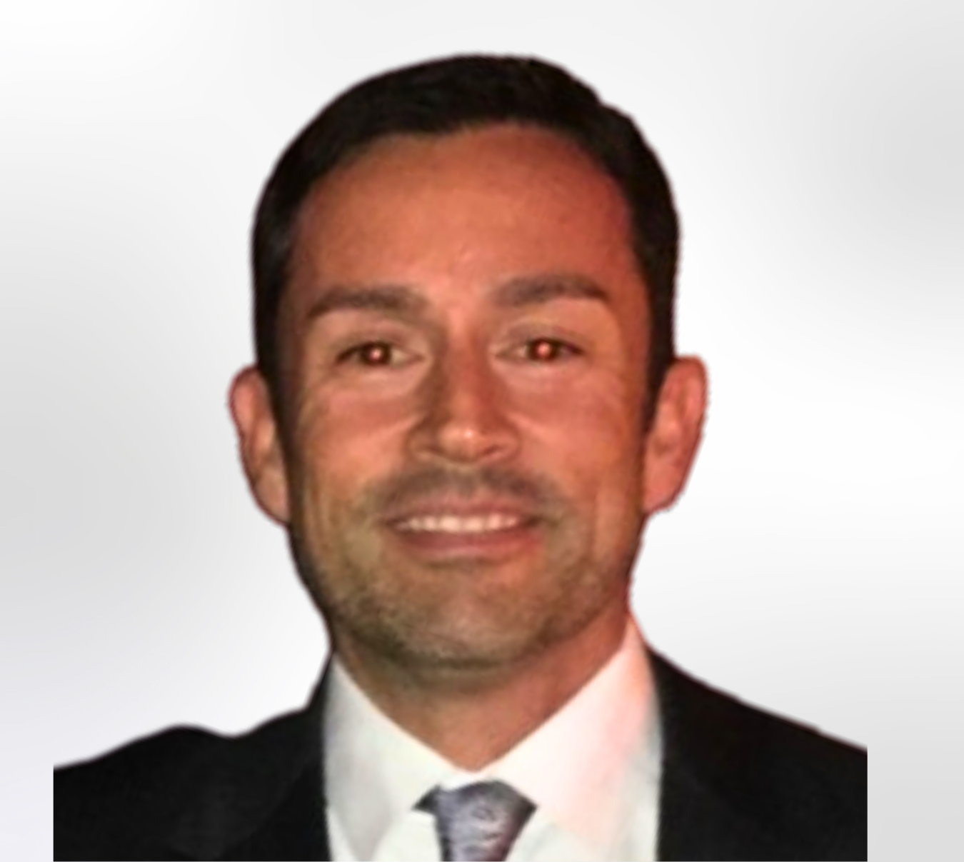 A man in a suit and tie is smiling for the camera.