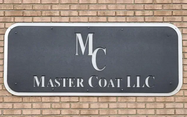 A dark grey sign with the letters