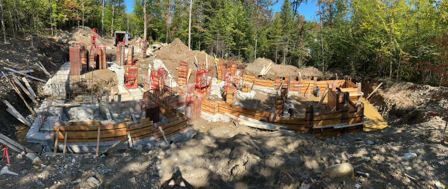 Un chantier avec beaucoup de terre et d'arbres en arrière-plan.