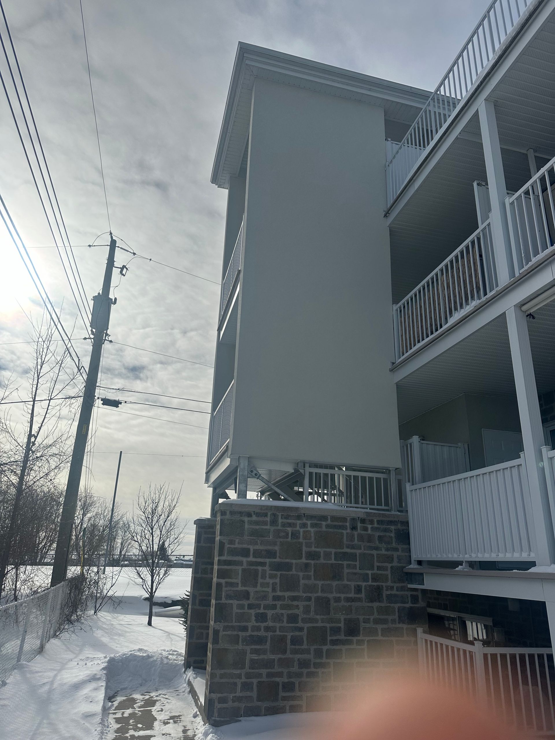 Un bâtiment avec beaucoup de fenêtres et de balcons est recouvert de neige.