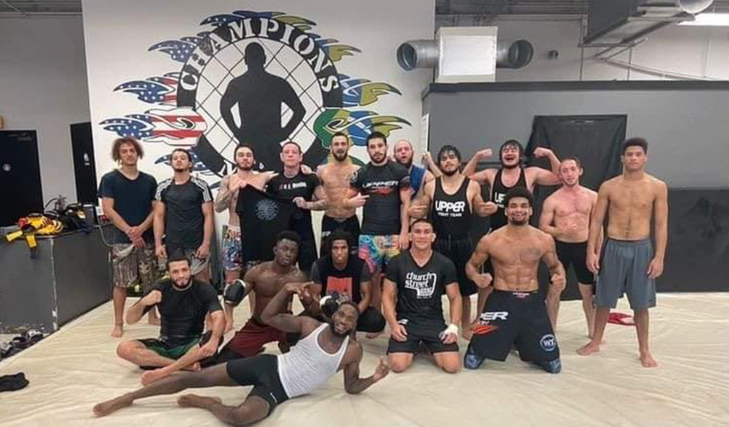 A group of men are posing for a picture in a gym.