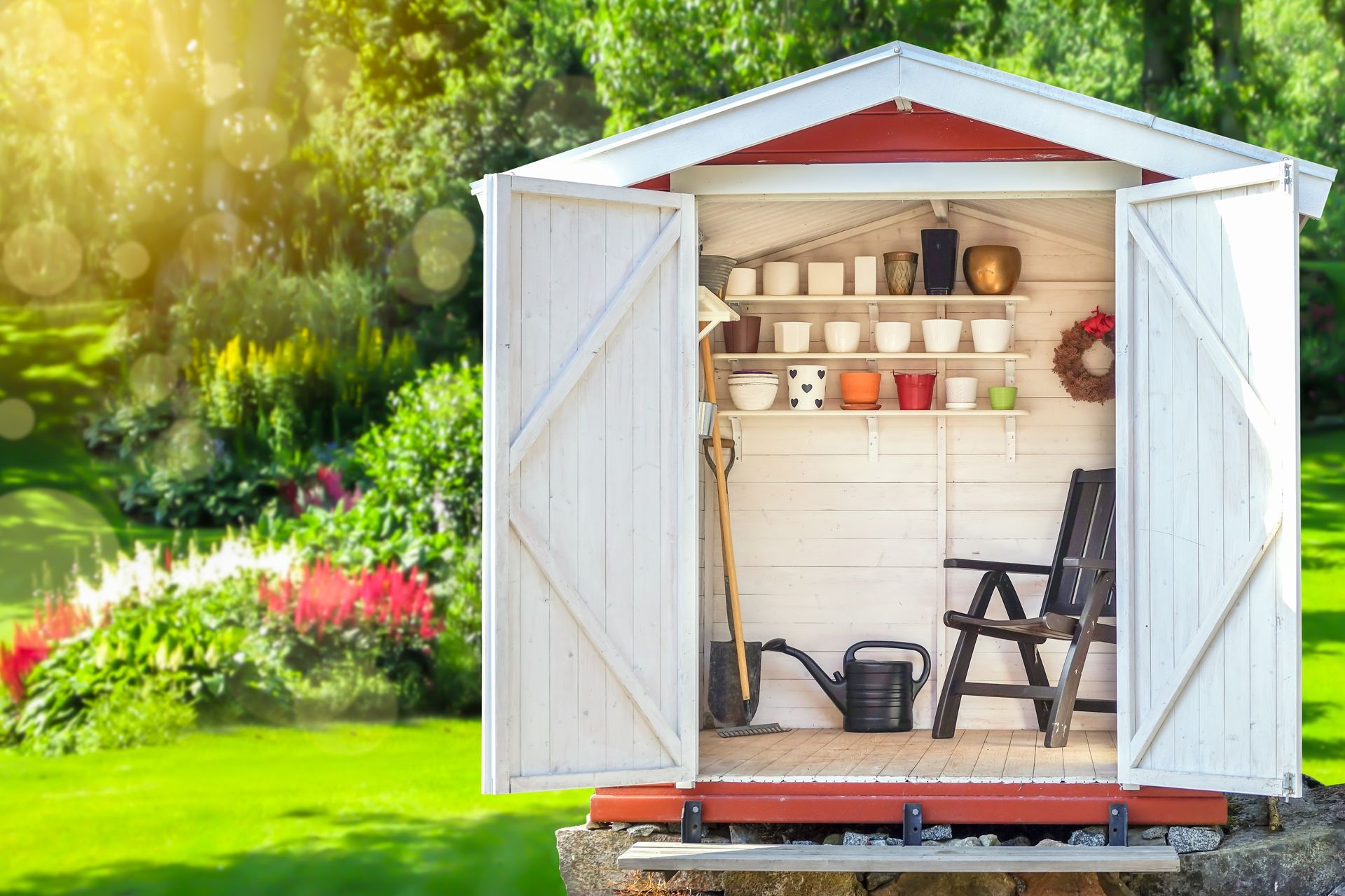 Garden shed filled with gardening tools. A green sunny garden in the background. Garden shed filled with gardening tools. A green sunny garden in the background.