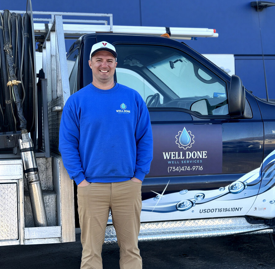 Travis Ostrowski | Well pump technician standing beside Well Done Well Services truck in Grass Lake Michigan