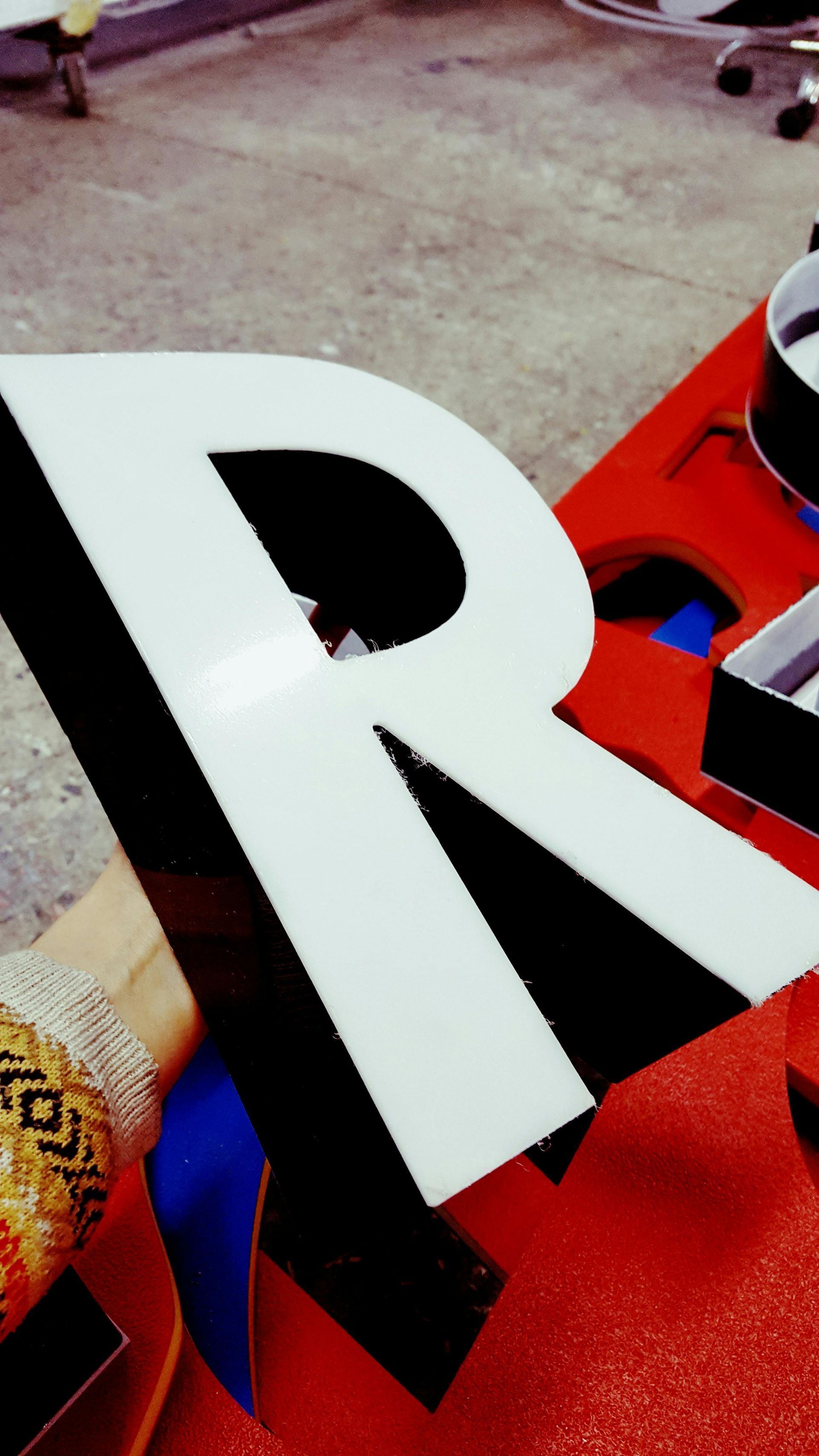 A black and white letter r is on a red surface
