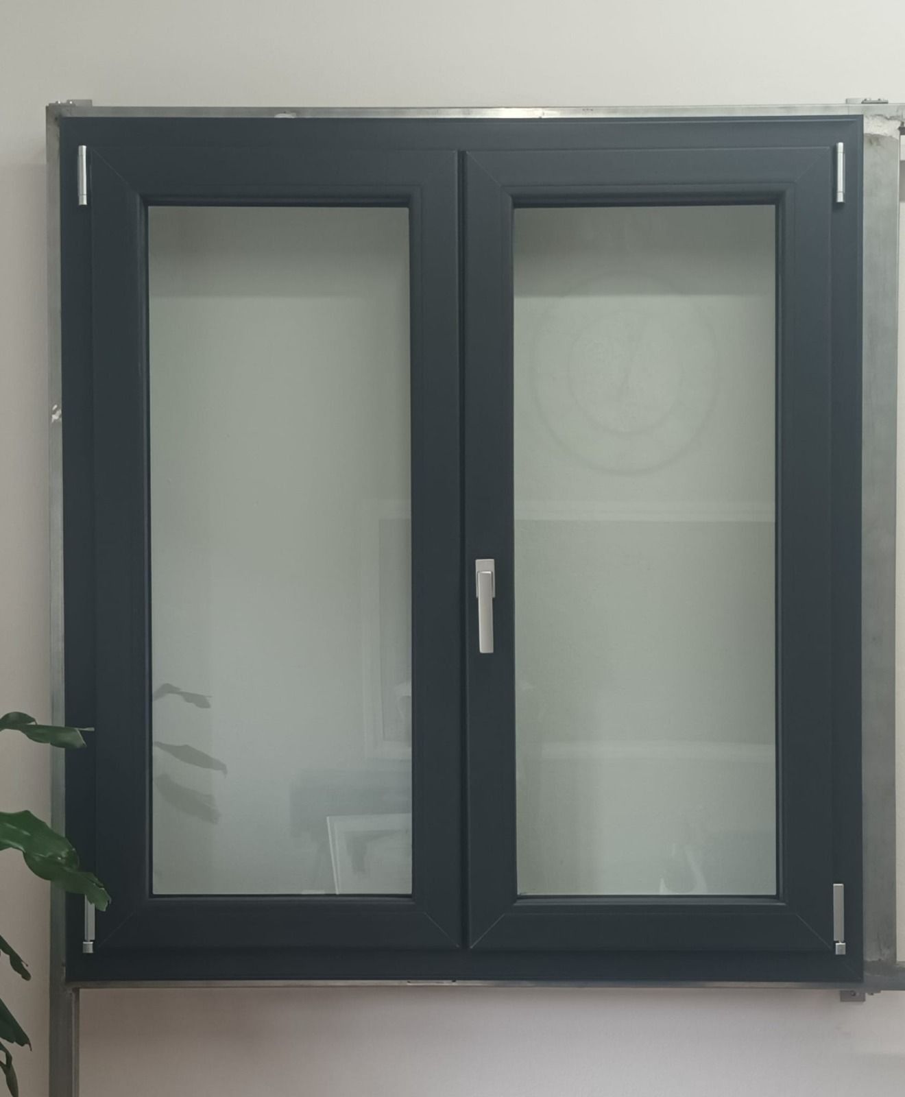 Mobiletto a muro grigio scuro con ante in vetro satinato e maniglia centrale.