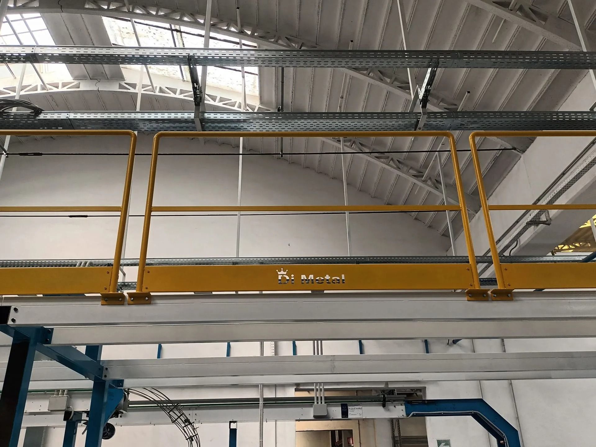 Parapetto/soppalco giallo all'interno di un magazzino industriale con soffitto metallico a vista.