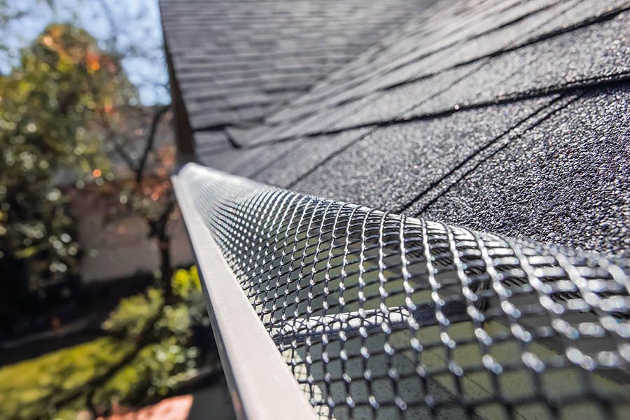 A close up of a gutter with a gutter guard on a roof.