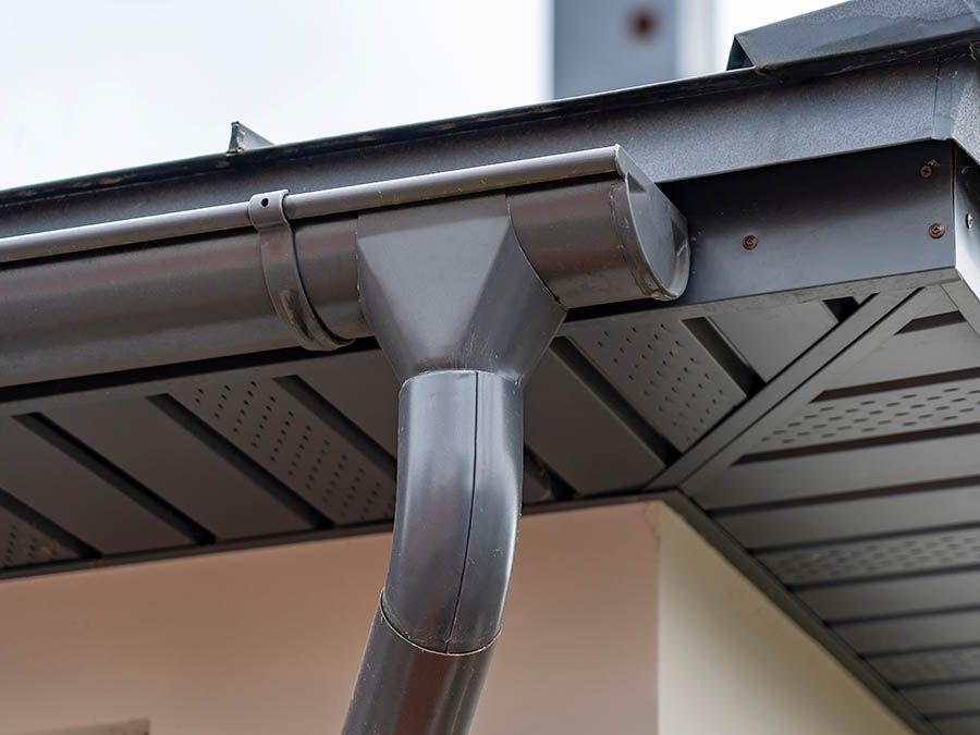 A close up of a gutter on the roof of a house.