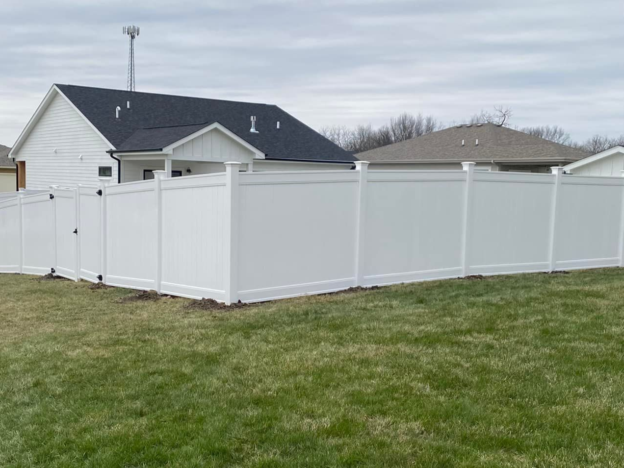 White vinyl fence enclosing a grassy backyard Ames, IA