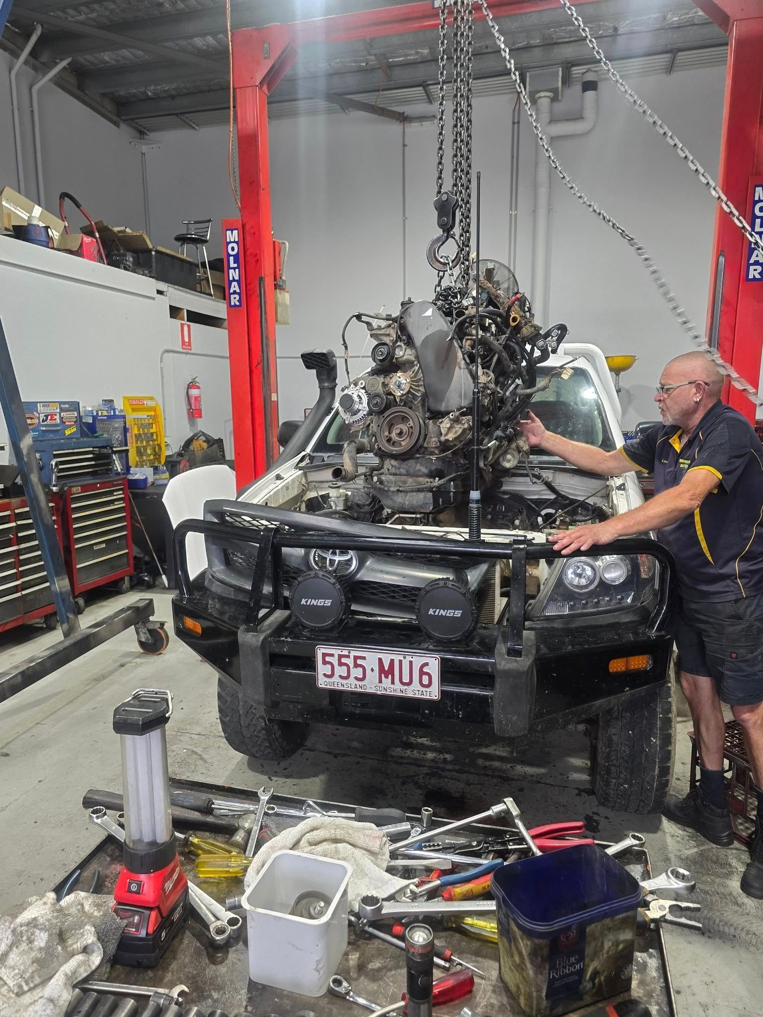 Engine Being Lifted From a White Truck in a Garage — Diesel Engine Rebuilding Australia in Gold Coast, QLD