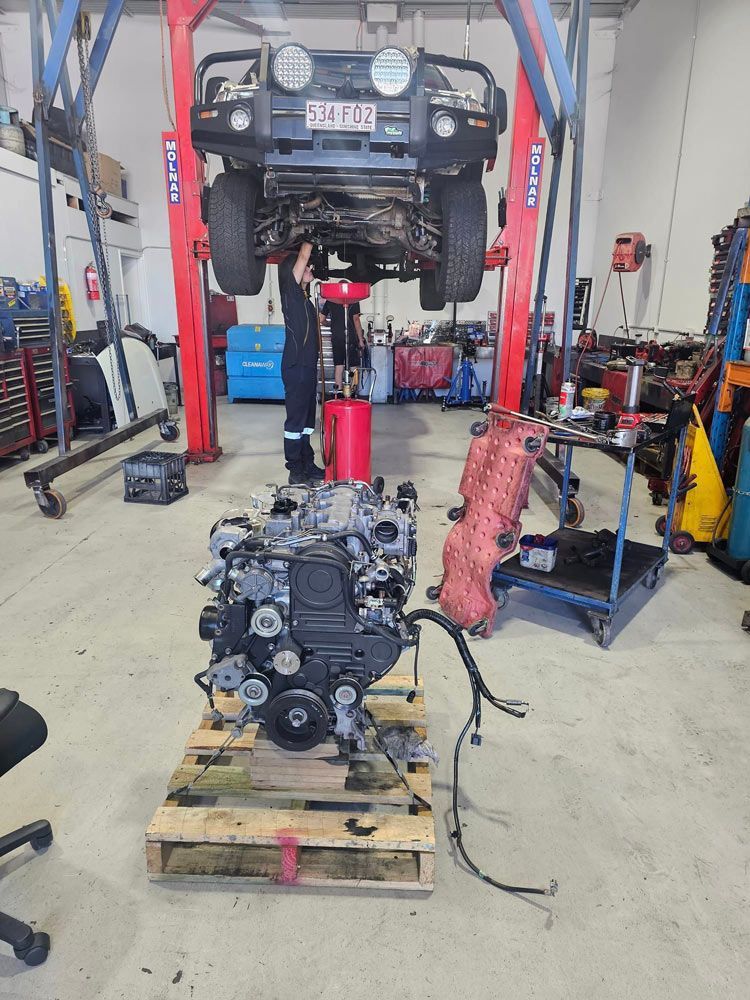 Car Hoist Lifting a Car in a Service Centre — Diesel Engine Rebuilding Australia in Gold Coast, QLD