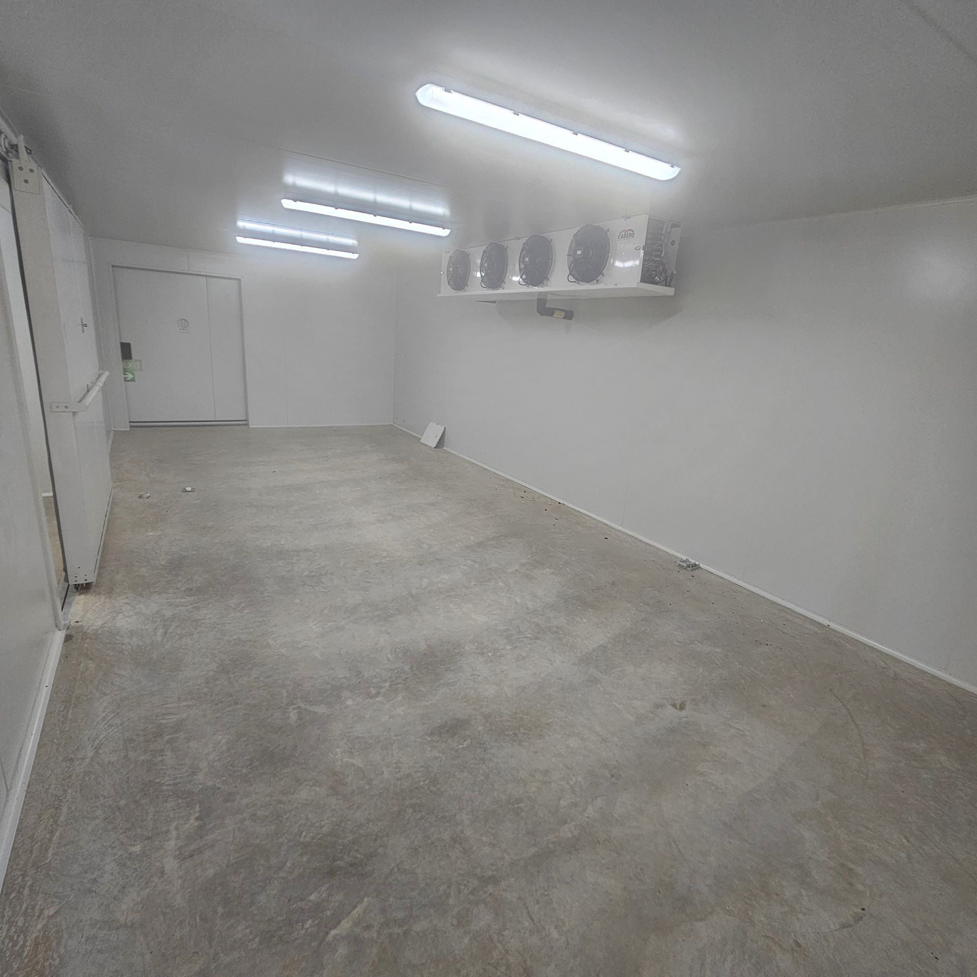 A Large Empty Room With a Concrete Floor and White Walls — Refrigeration & Air Conditioning in Katherine East, NT