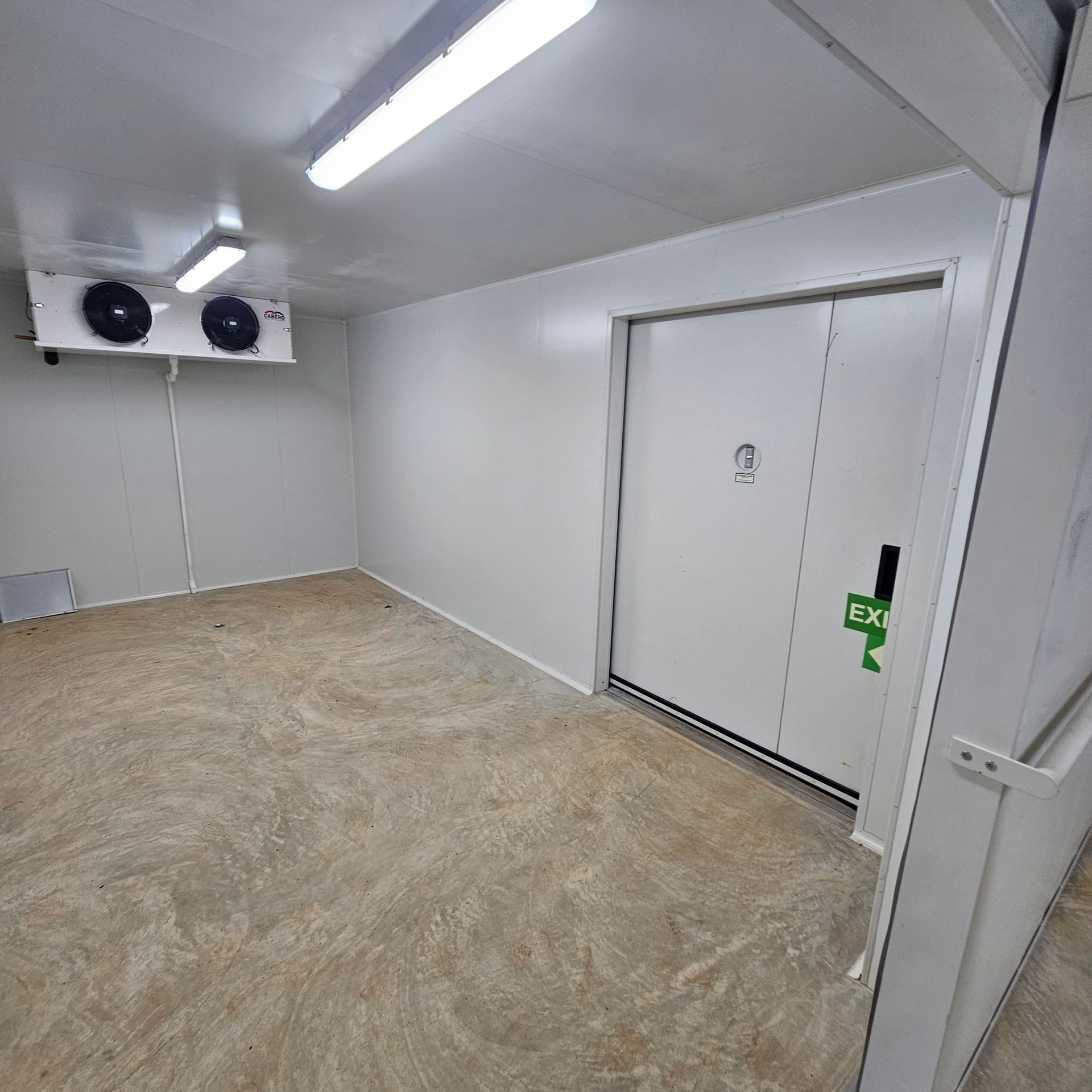 A Room With a Green Exit Sign on the Door — Refrigeration & Air Conditioning in Katherine East, NT