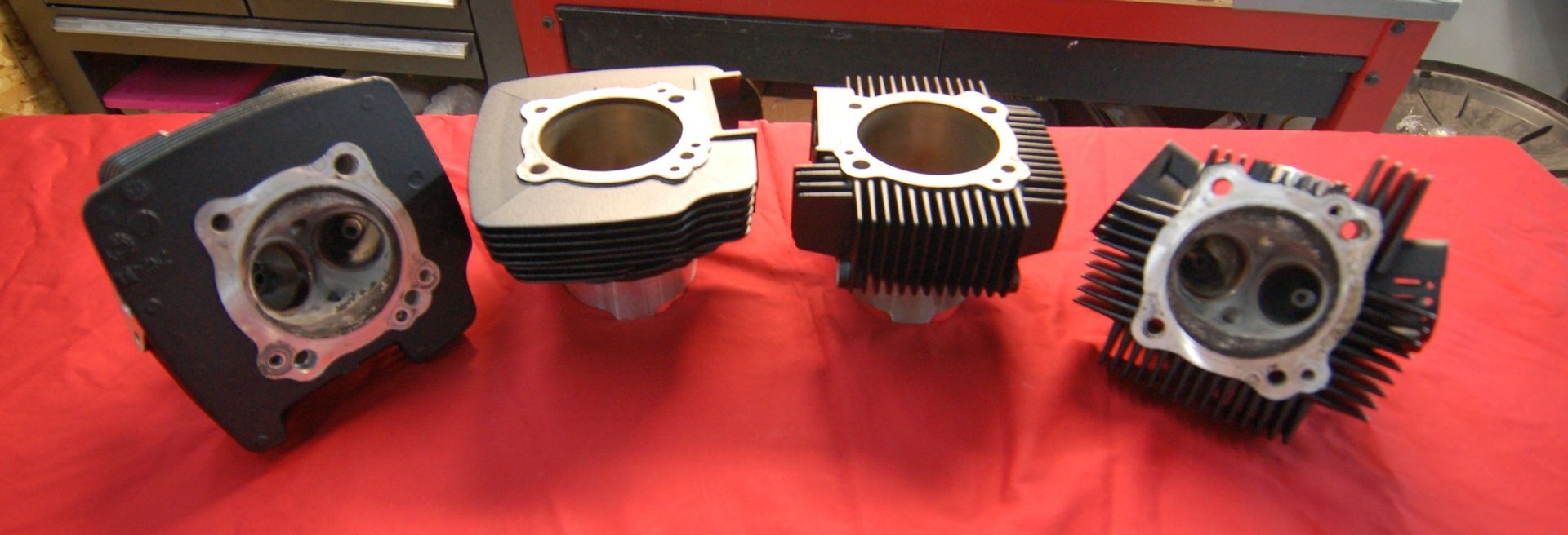 Four cylinders are sitting on a red cloth on a table