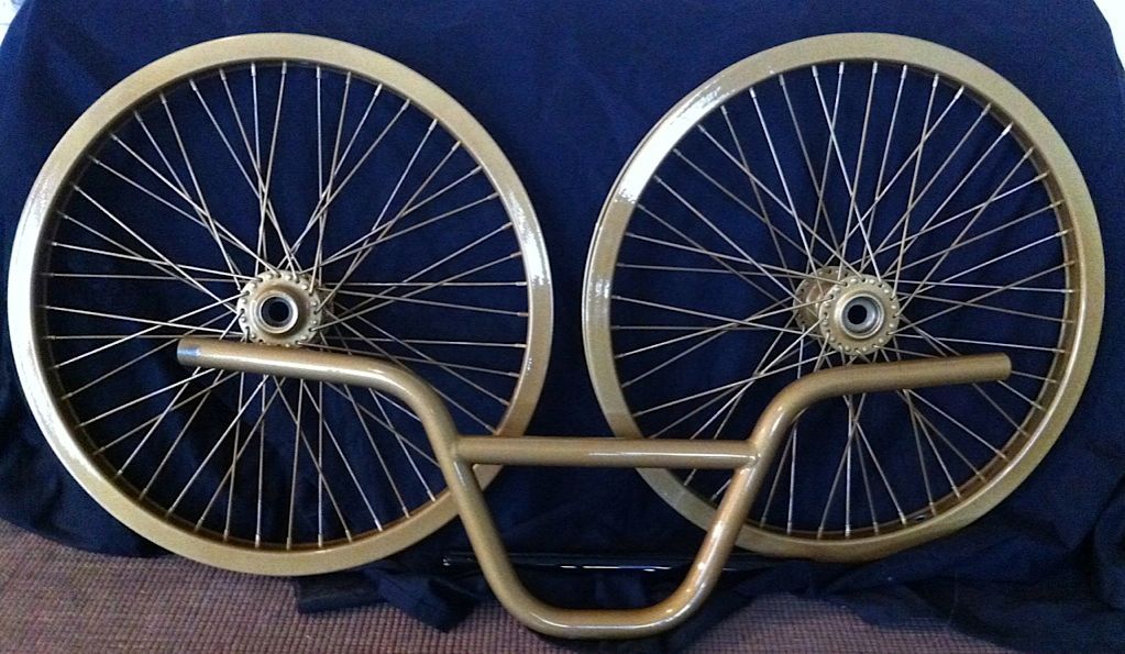 Une paire de roues et de guidons de vélo dorés sur un tissu bleu