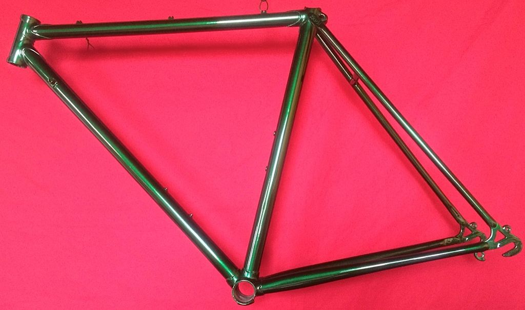Un cadre de vélo vert est posé sur un tissu rouge