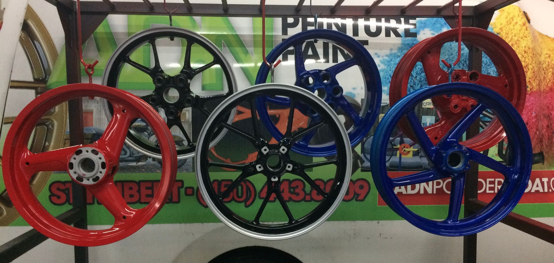 A bunch of wheels are sitting on top of each other on a stand.