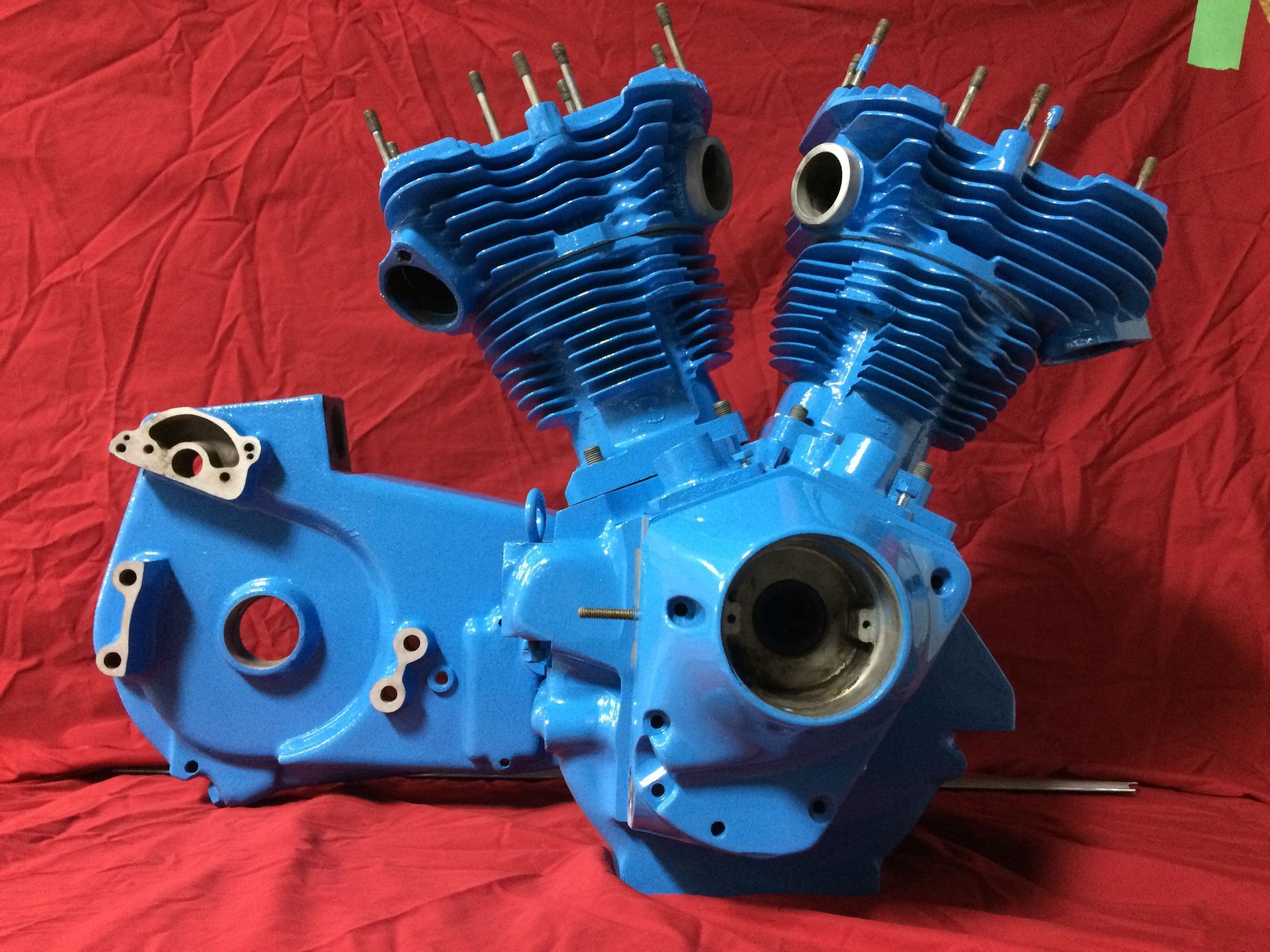 A blue motorcycle engine is sitting on a red cloth