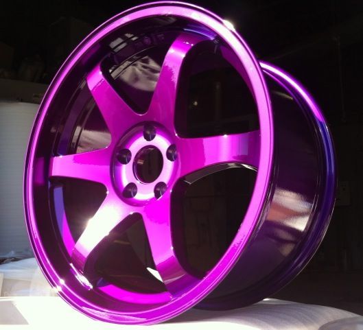 Une roue violette est posée sur une surface blanche