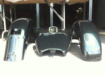 A motorcycle tank and fenders are sitting on a table.