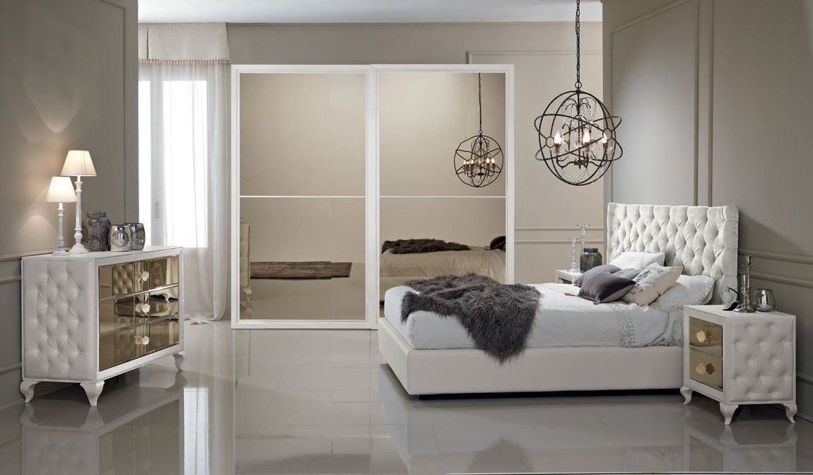 Una camera da letto con letto, comodino, cassettiera e armadio scorrevole.