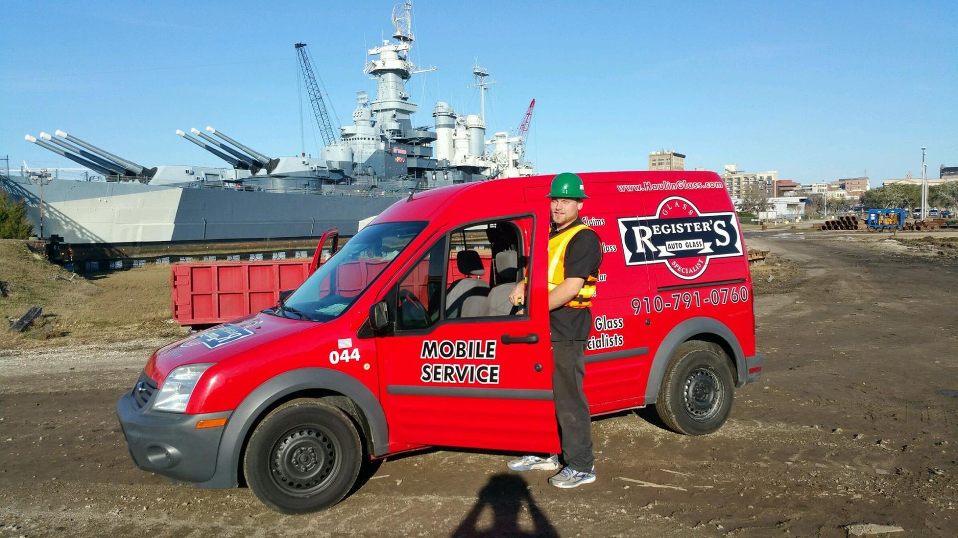 A man is standing next to a red van
