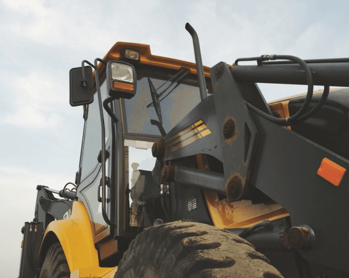 A yellow and black tractor is parked in a field