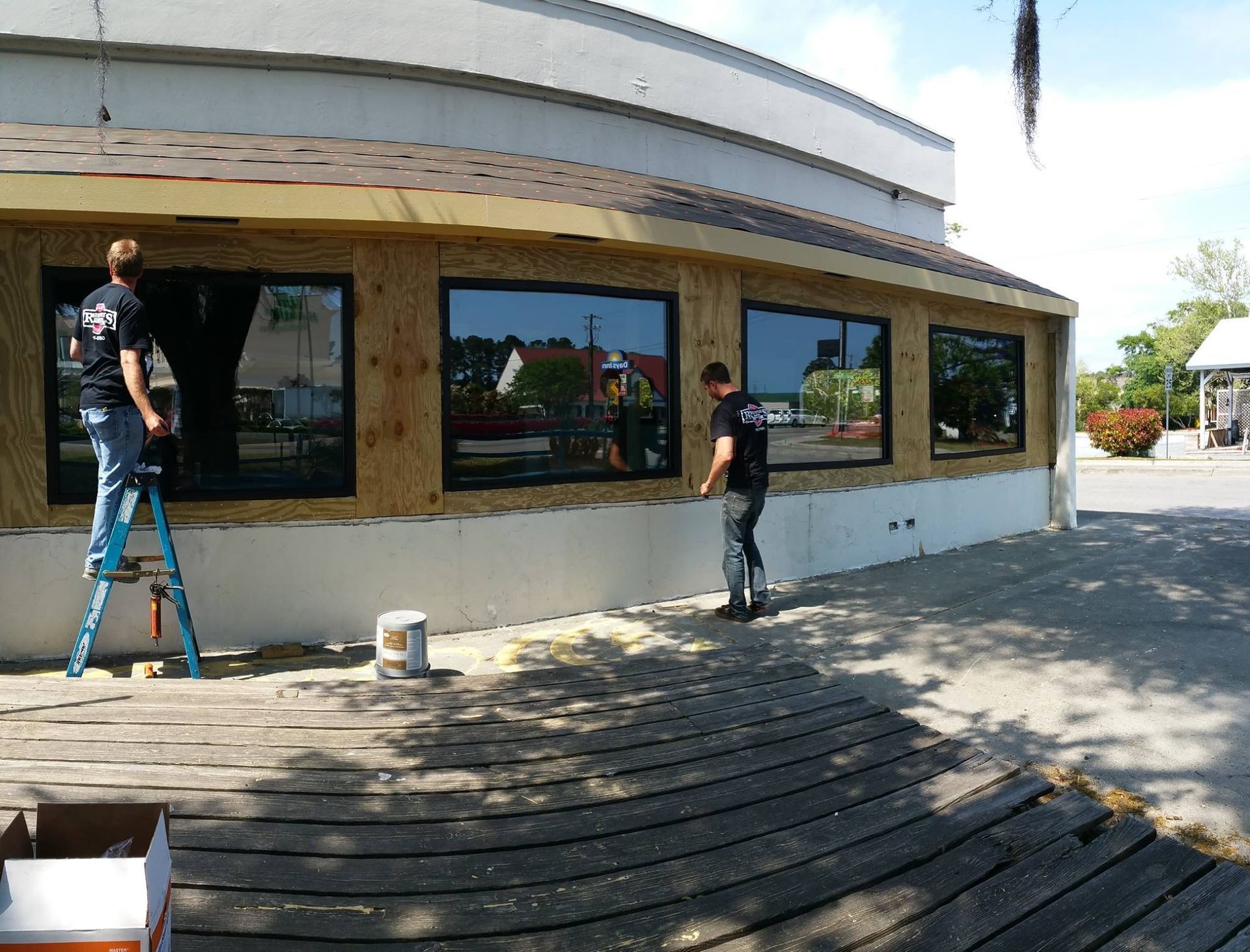 Two men are working on the side of a building