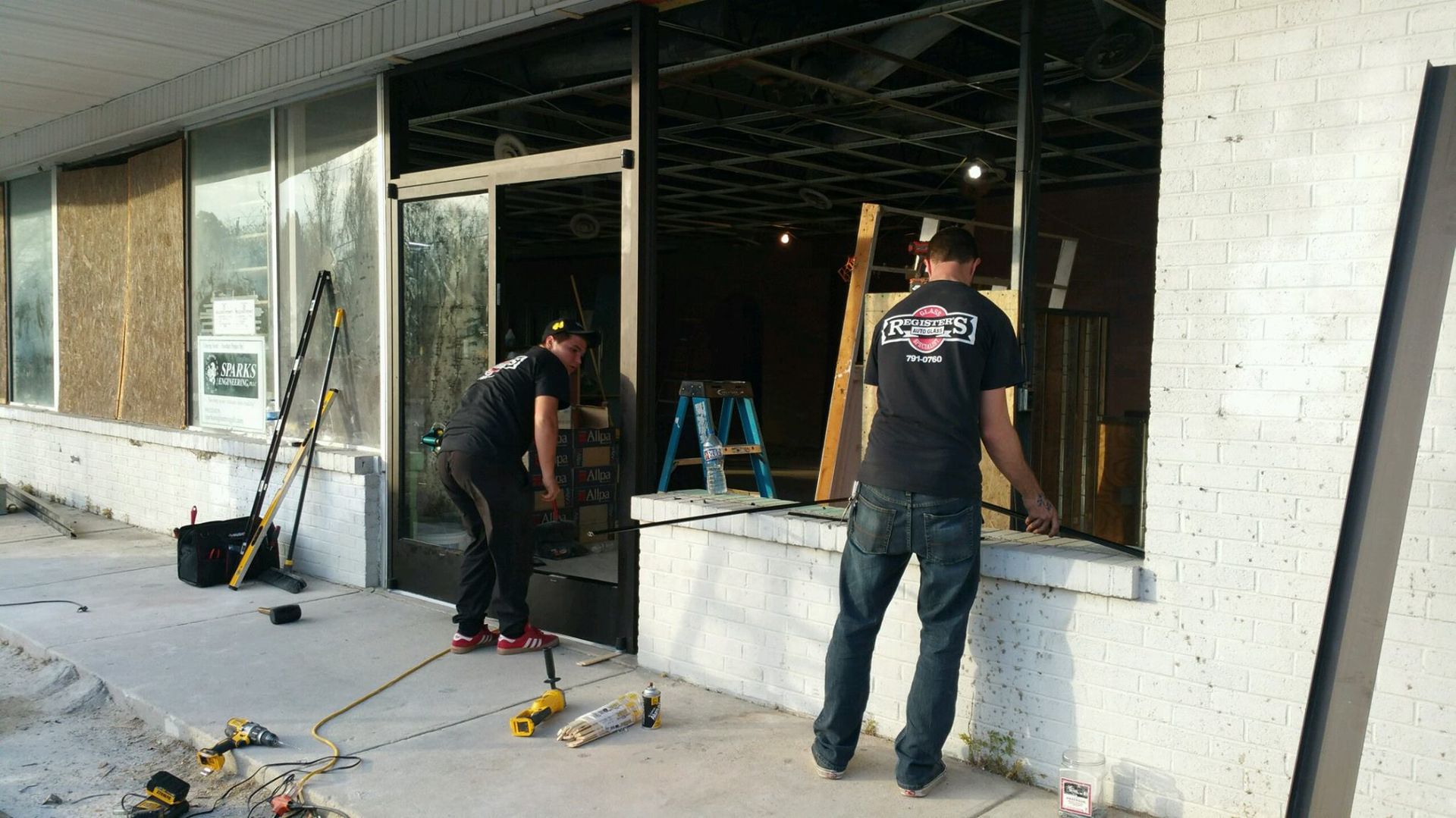 Two men are working on a building with a pepsi logo on their backs