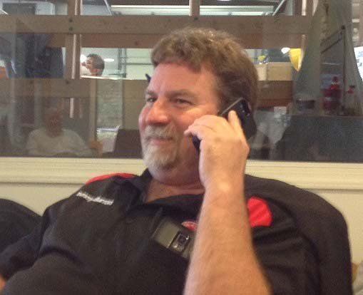 A man in a black shirt is talking on a cell phone