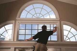 A man is standing in front of a large window