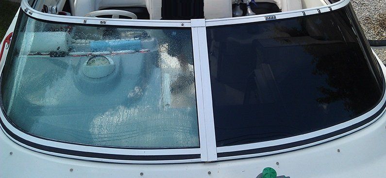 A white boat with a green leaf on the windshield